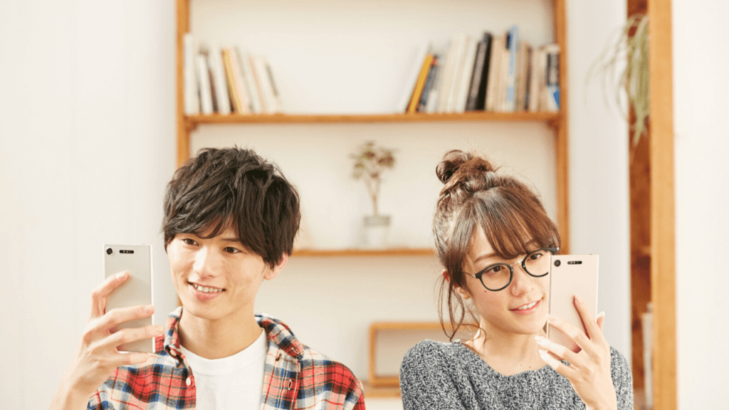 それぞれスマートフォンで調べ物をしているカップル