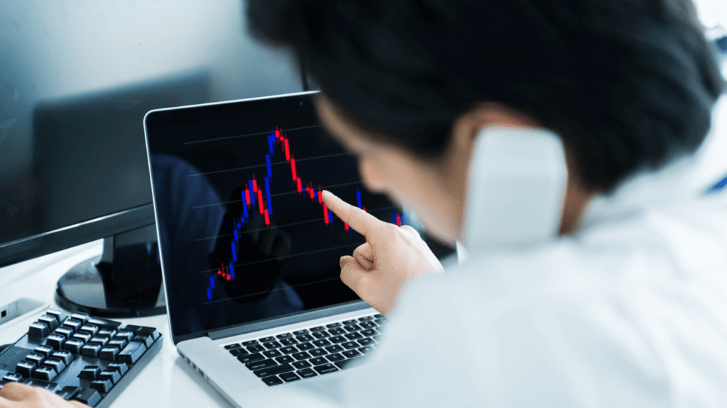 チャートを見ながら電話をしている男性