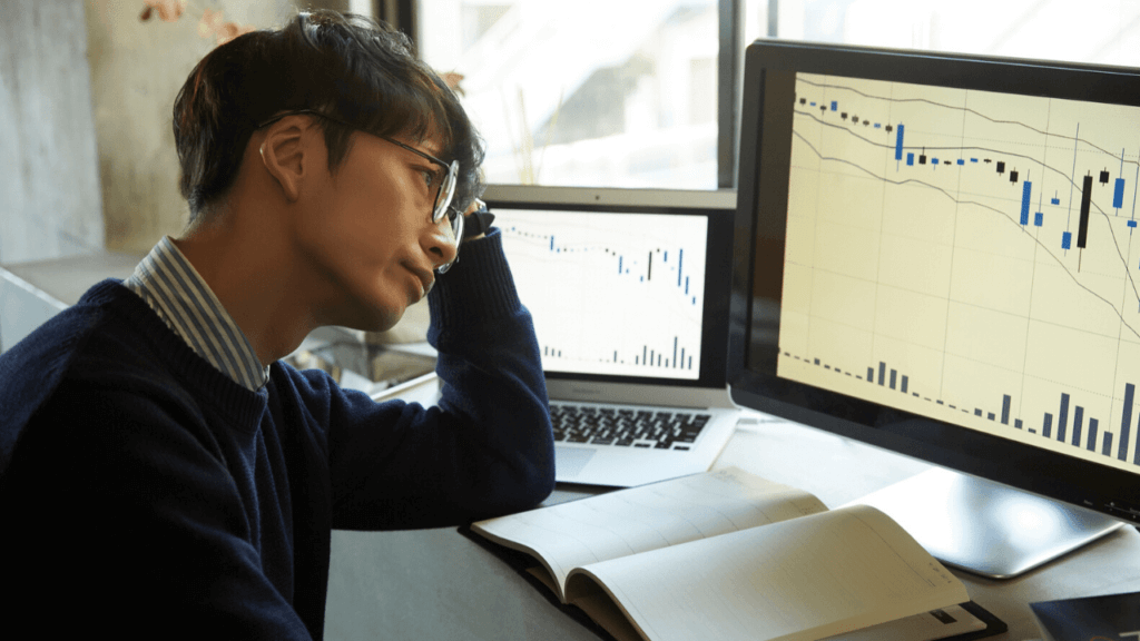 チャートを見て悩んでいる男性