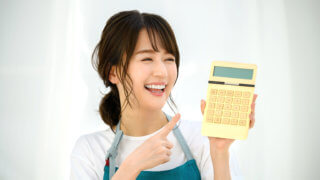 笑顔で電卓を見る女性