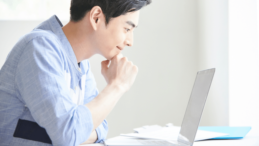 パソコンを覗く若い男性