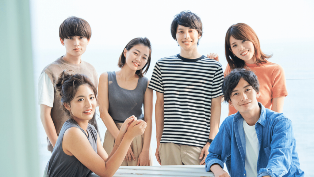 笑顔でこちらを向く若い男女グループ
