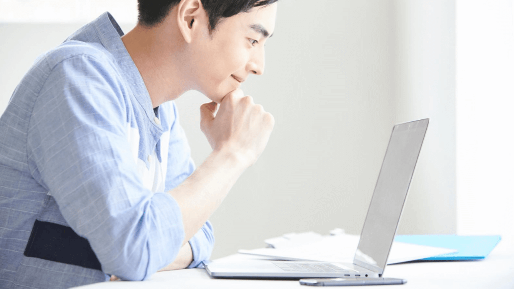 パソコンで金融商品を調べる男性