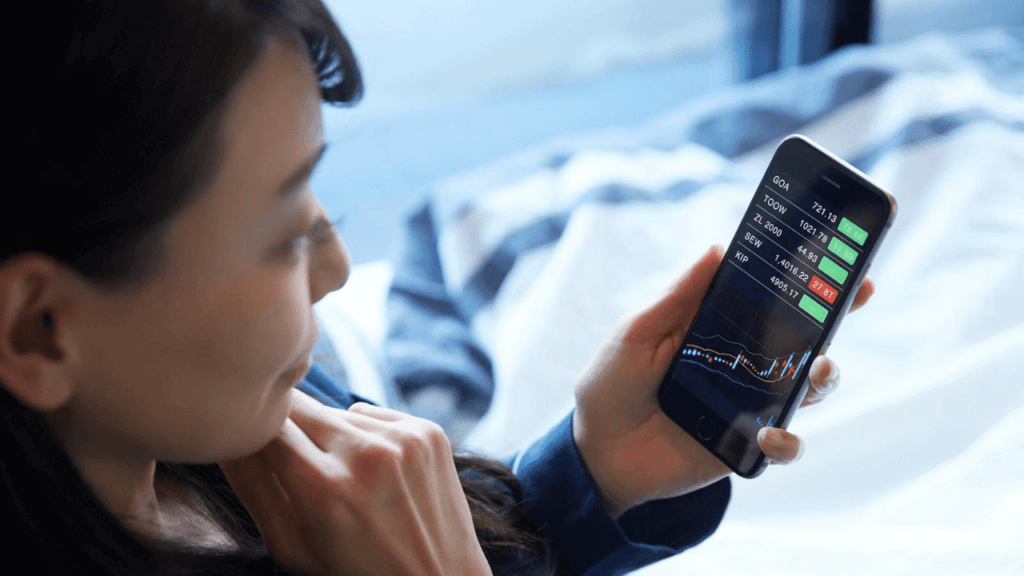 スマホでチャートをチェックする女性